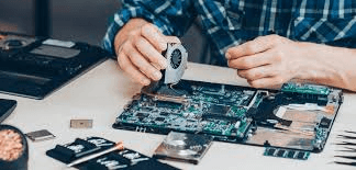 Technician repairing circuit board with precision tools